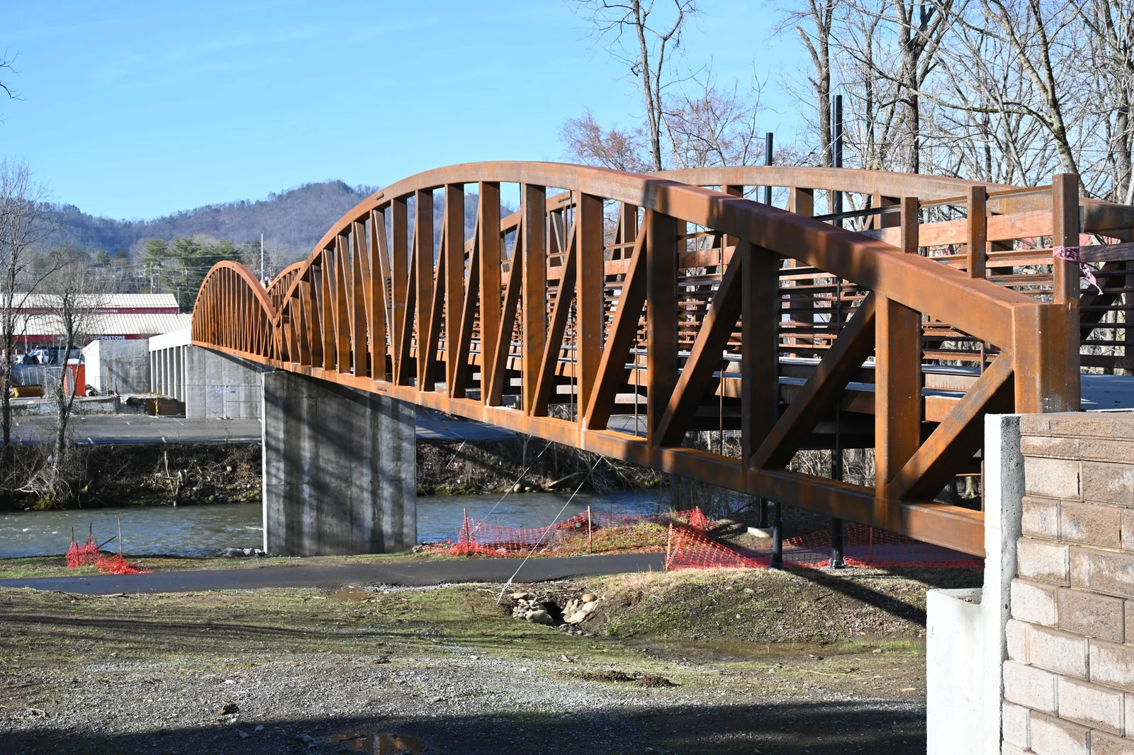 Wide side view of the Rockin’ Three Bears pedestrian bridge over the river in Pigeon Forge.